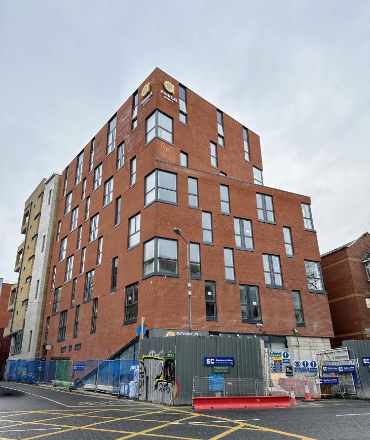 The exterior of the Point A Liberties hotel. A red brick building with the 'Point A' sign at the top.
