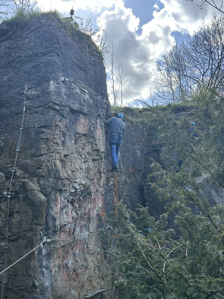 John Robson in a safety gear and harness taking on the Via Ferrata challenge on a rock face in a quarry