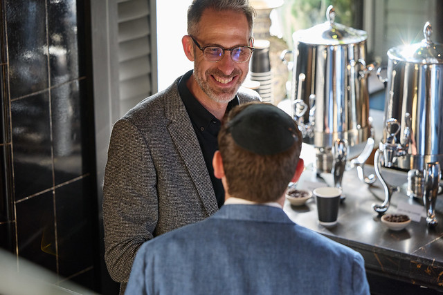 Nik Clarke, Director smiling and chatting to another guest who has his back turned to the camera.