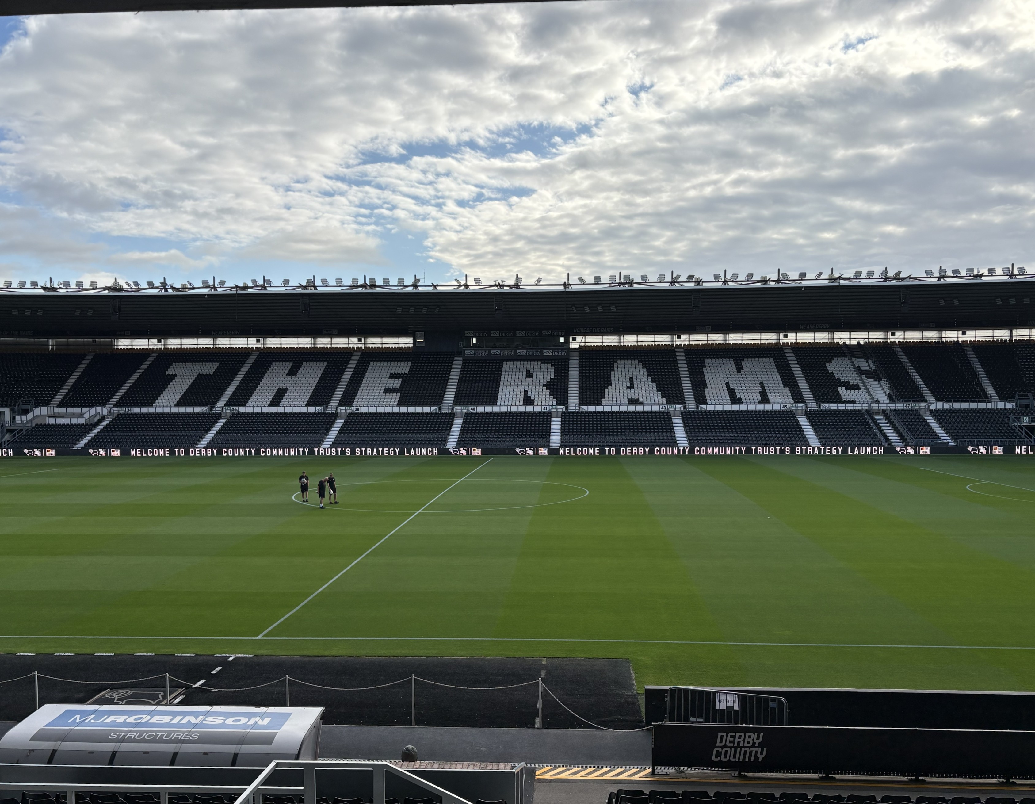 A photograph of the Pride Park pitch with 'The Rams' spelt out in the stadium seating opposite.